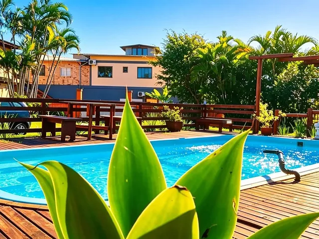 Piscina da Pousada Aurema, com jardim tropical ao redor