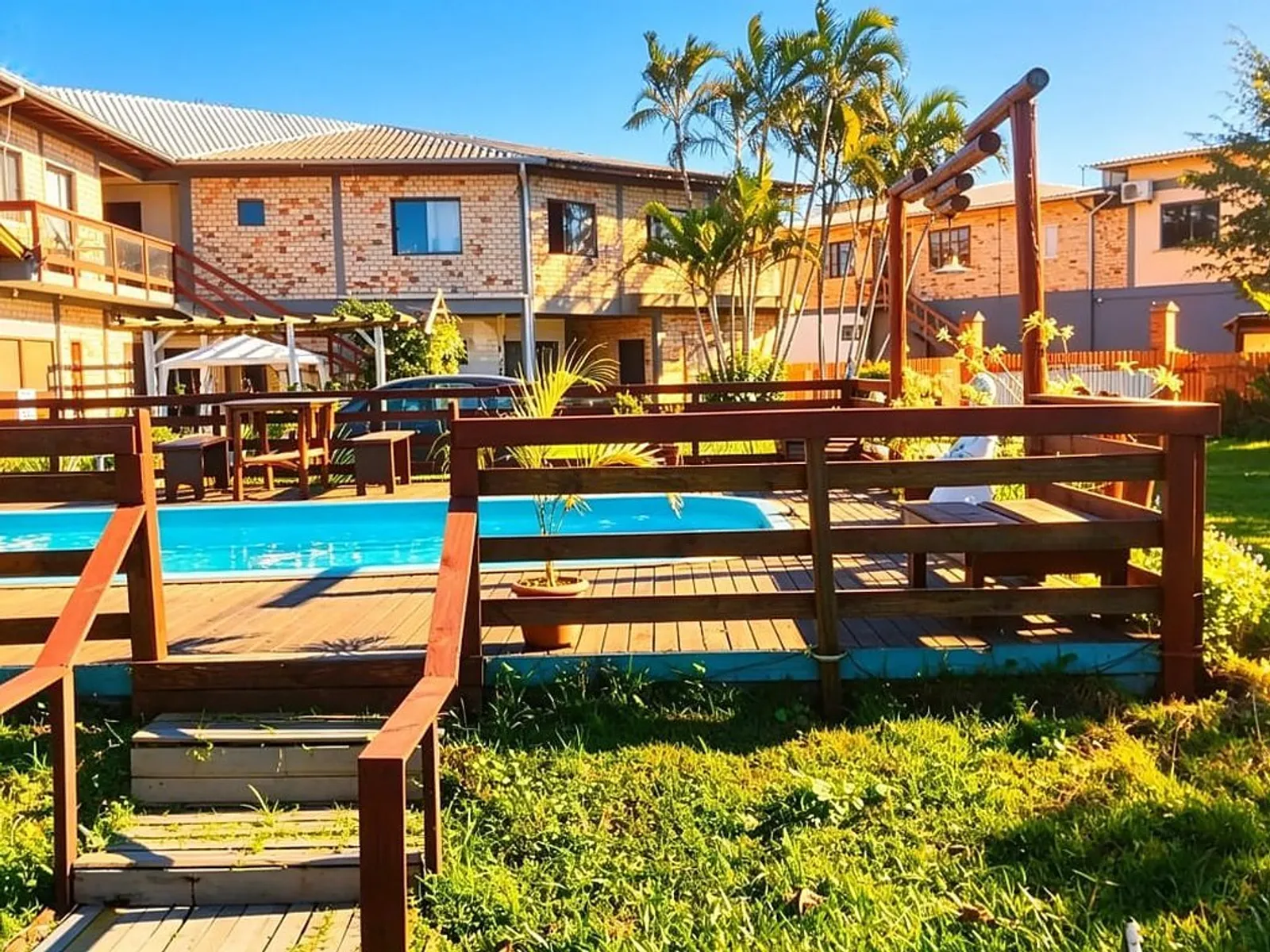Piscina e área externa da Pousada Aurema, com a fachada ao fundo